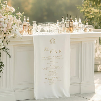 White bar setup with floral decorations and a 'The Bar' sign in an outdoor setting.