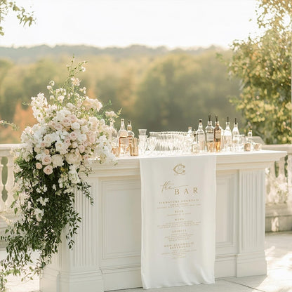 Decorative outdoor bar setup with flowers and bottles on a sunny day.
